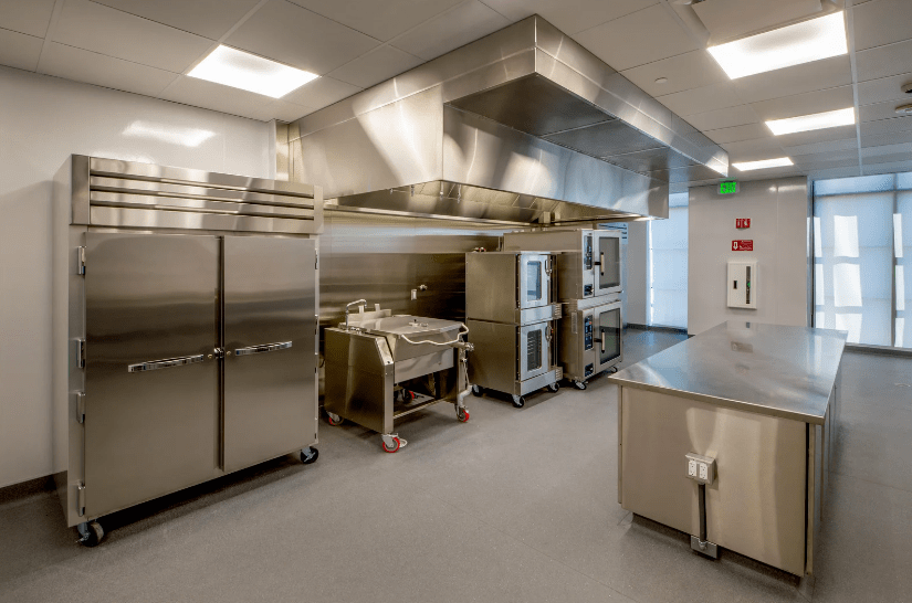 An industrial kitchen used for food catering with equipment operated using wheels and castors.
