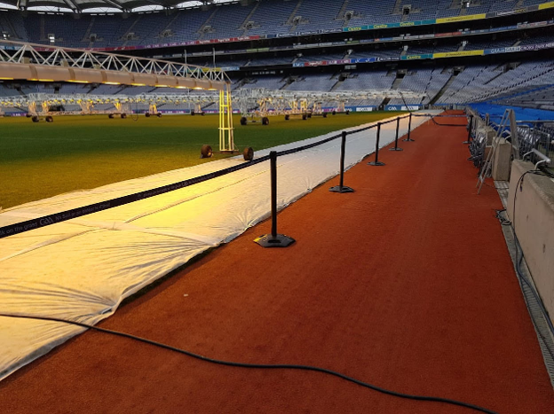 Crowd control barriers are installed around a stadium event area to guide attendees safely and maintain organised pedestrian flow.