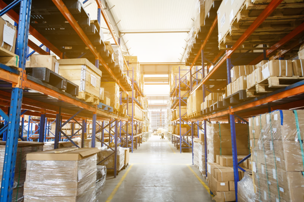 Warehouse storage facility using material handling equipment to move and organise inventory across racking systems.
