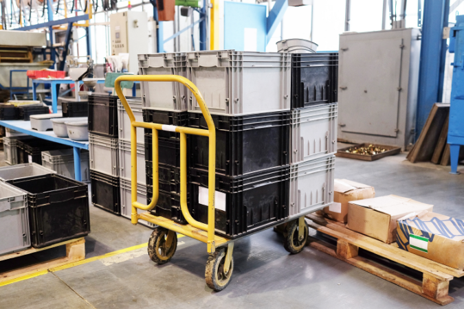 A trolley holding boxes in a manufacturing warehouse to show why different trolley wheels would be needed. 